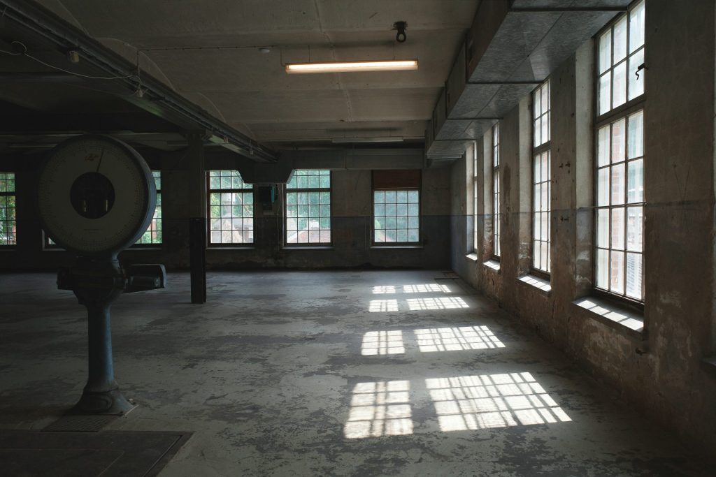 Empty industrial room with large windows and old scale