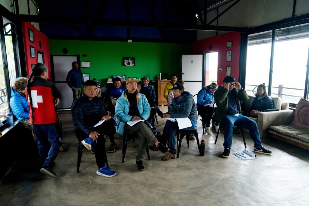 A group of people sitting around each other in a room